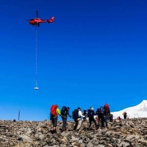 En helikopter flyger över våra besökares vandring på Kebnekaise